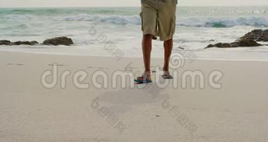 在阳光明媚的4k天气里，<strong>一个人</strong>赤脚在海滩上<strong>行走</strong>